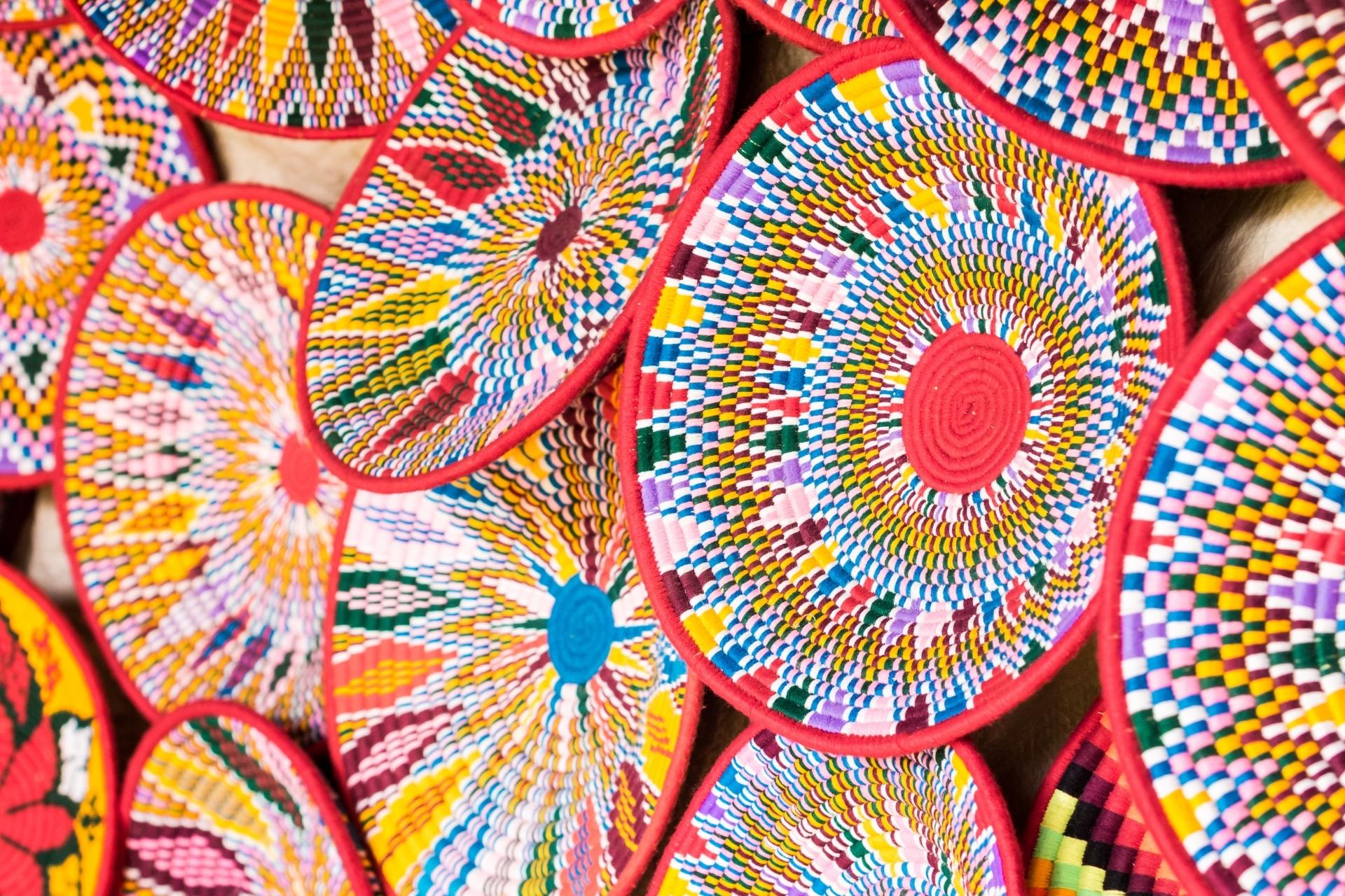 Vibrant geometric patterns of traditional Ethiopian handwoven coiled grass baskets, decorative Mesob covers, and artisan crafts